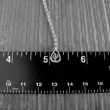 Silver necklace with a cactus pendant on a ruler for scale