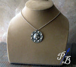 black and silver round pendant necklace shown on tan bust