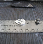 alien tie tack pin on ruler and gray tile
