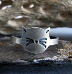 cat face ring with whiskers on rock with driftwood