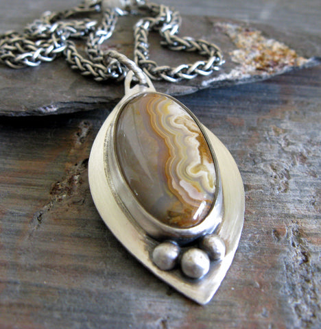 Sterling Silver marquise pendant with sand colored gemstone on gray stone