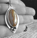 Sterling Silver marquise pendant with sand colored gemstone in hand