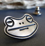 silver and black frog face tie tack on black with driftwood