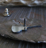 Back side of guita lapel pin in gray rock