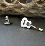Acoustic Guitar tie tack pin on gray background with driftwood