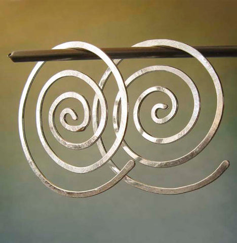 Spiral hoop earrings on gradient background