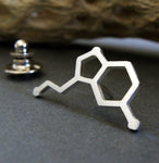 silver serotonin molecule tie tack on gray background
