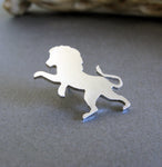 Silver standing lion tie tack on gray background