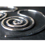 Close up of silver spiral earring on black background