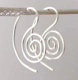 hanging silver spiral earrings on gray background