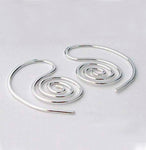 silver spiral earrings on gray background