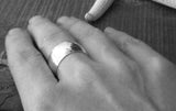 Wide sterling silver ring band shown on hand in black and white