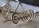close up of gold spiral earrings