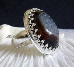Side view of sterling silver gemstone ring on black and white