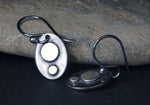 silver dot oavl earrings on black leaning on gray rock