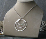 Large 3 circle silver pendant necklace on tan bust