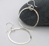 silver dangle hoop earrings on white background with gray rock
