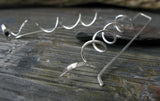 Spiral silver earring on gray tile