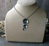 black silver disc trip pendant necklace shown on tan bust