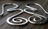 Silver ripple wave earrings with spiral on gray stone