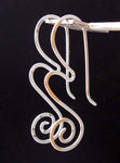 Silver wave and spiral hanging earrings on dark background