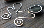 Silver wave and spiral wire earrings on gray stone