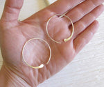 silver hoop earrings shown in hand