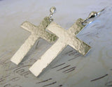 silver cross dangle earrings on pastel background